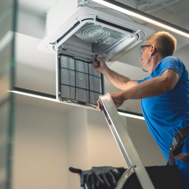 Technical maintenance worker repairs the air conditioning system